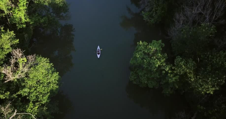 A person kayaks through a river