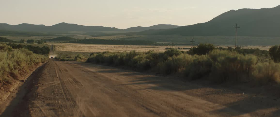A car driving on a dirt road in the country