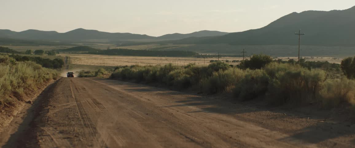 A car driving on a dirt road in the countryside