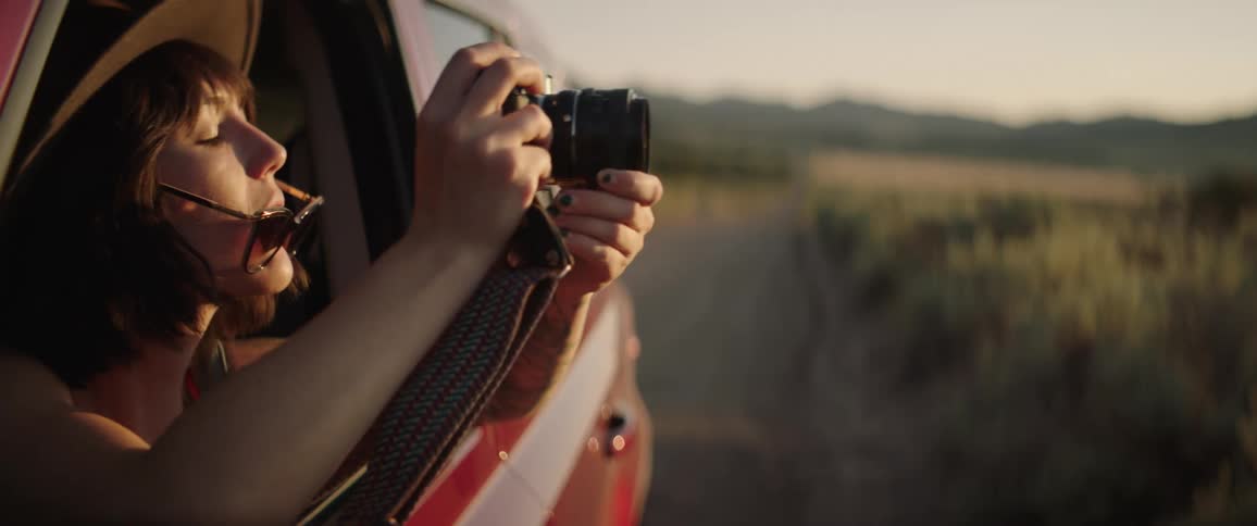 A woman taking a photo in a car