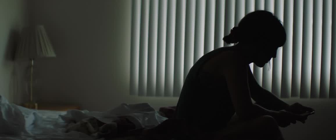 A silhouette of a woman on her phone