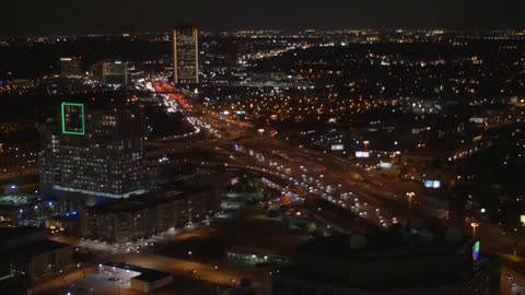 Vehicles travel down a busy city road at night