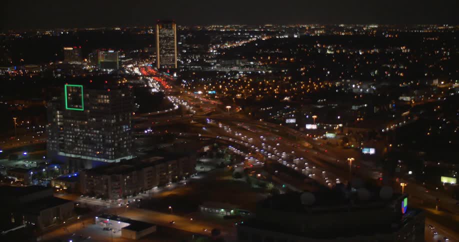 Vehicles travel down a busy city road at night