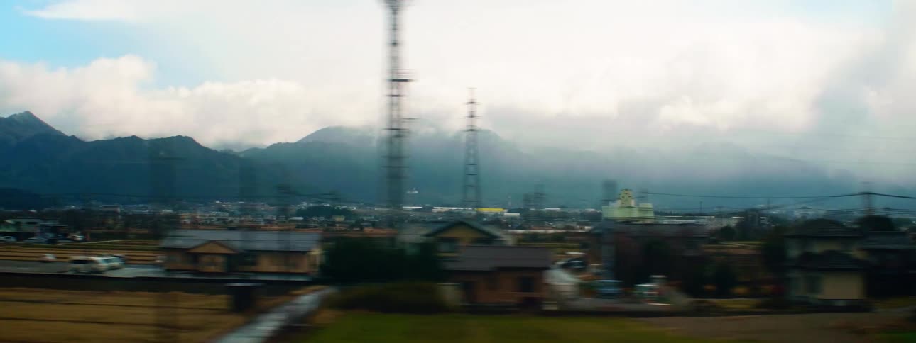 Town buildings stretch toward fog covered mountains