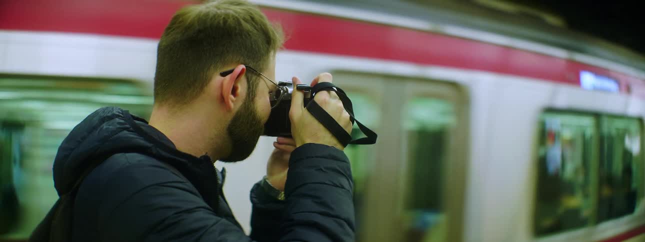 A man takes pictures as a train drives past him