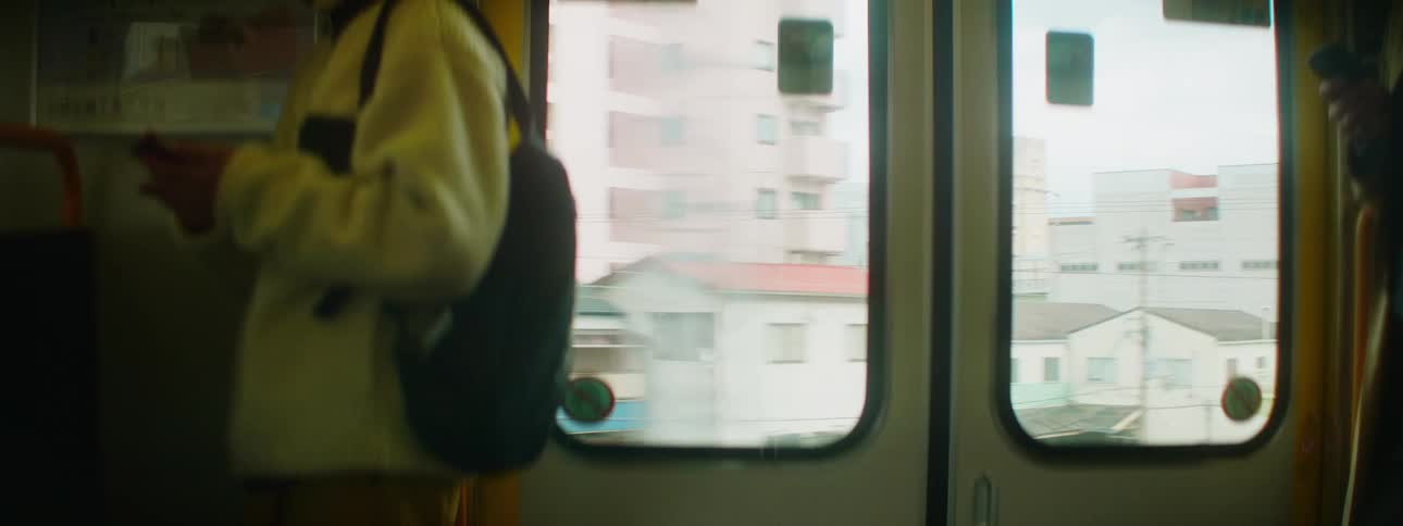 Passengers stand on public transport near door showing city