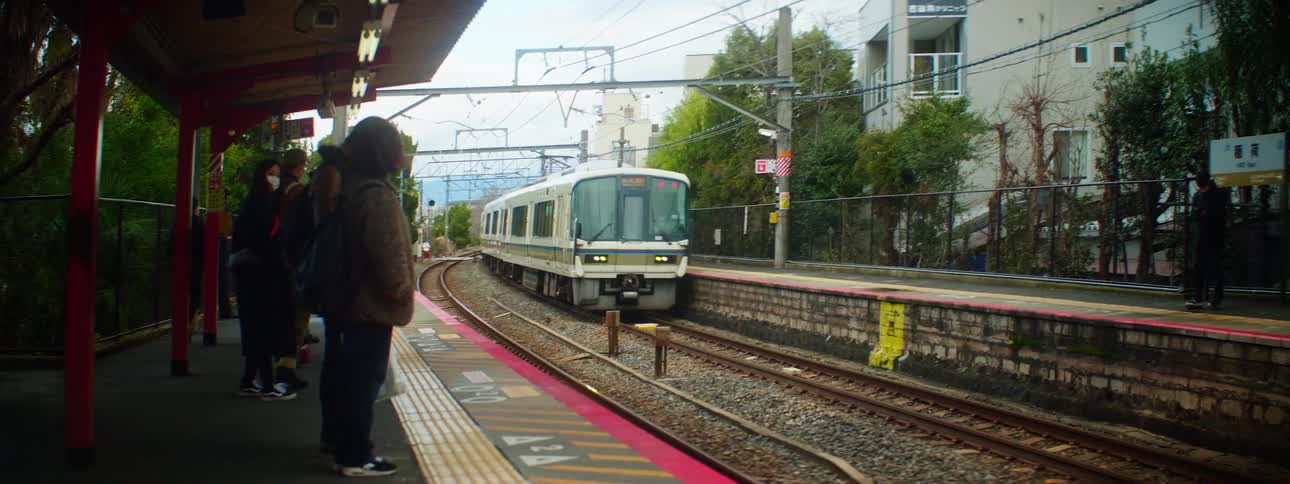 People waiting on a platform at a station as a subway drives past