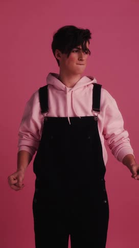 A young teenager stands in one spot and dances