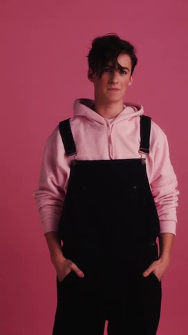 A young teen poses in front of a back drop