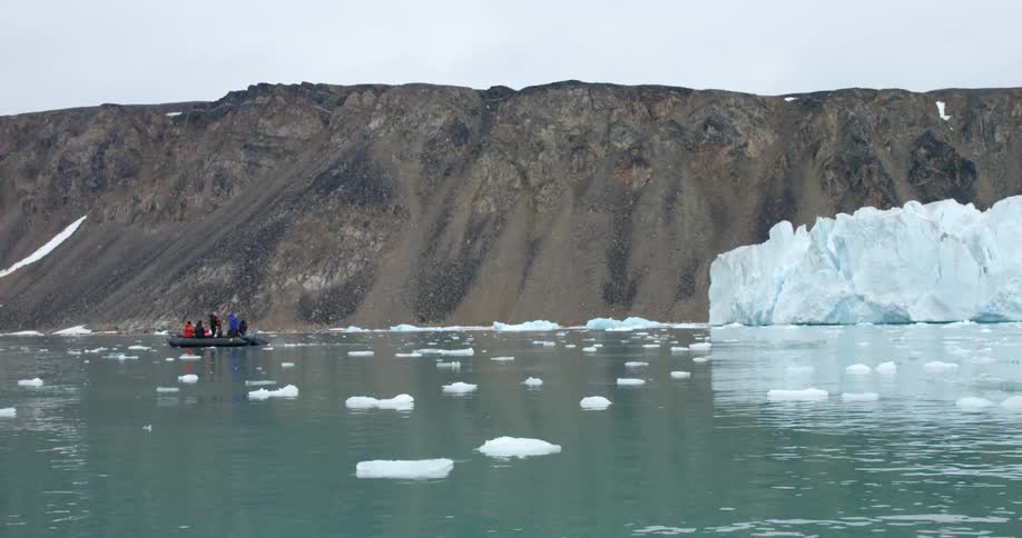 A raft is floating in the water near a mountain