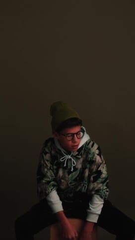 A young boy sits on a box and looks around