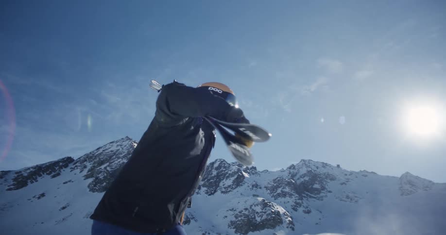 Snow skier carrying skis across the snow to lift line