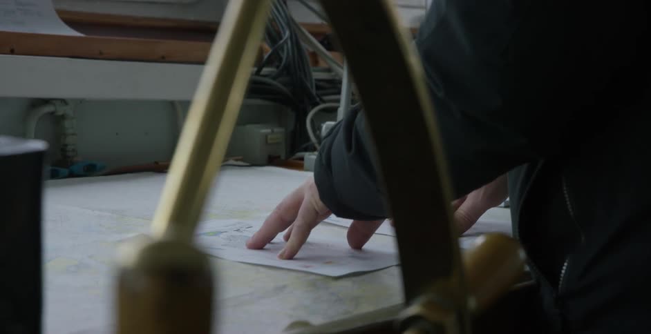 A man is looking at a map inside a ship