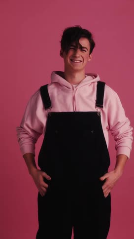 A teenager stands in front of a back drop and smiles