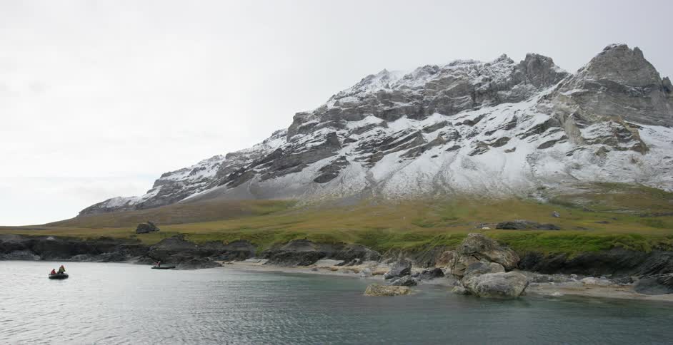 A small boat is in the water near the shore