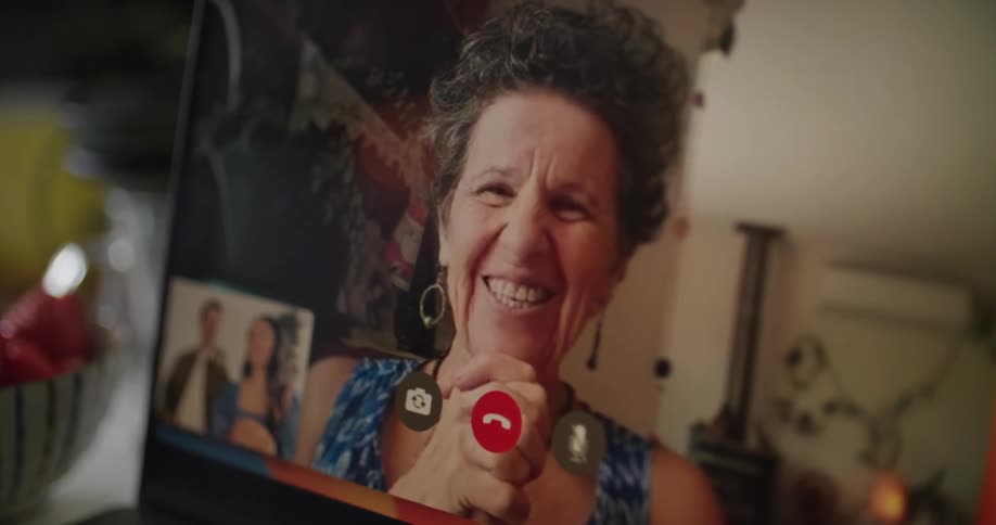 Mother in law having face time chat with happy couple on laptop smiling laughing