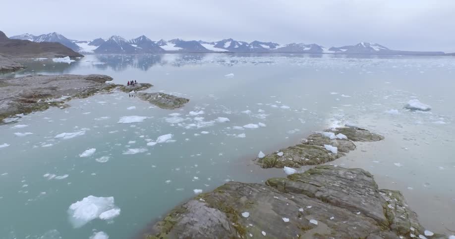 People are on small islands in the ice filled water