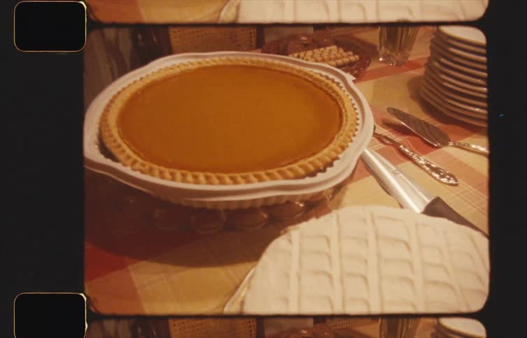 Home movie footage of desert table with a cake and pumpkin pie probably thanksgiving