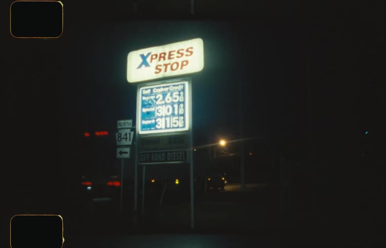 Vintage footage of xpress stop filling station off of interstate freeway at nighttime