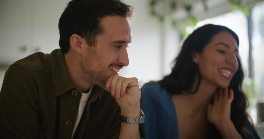 A man and woman talk to each other while looking at a laptop computer