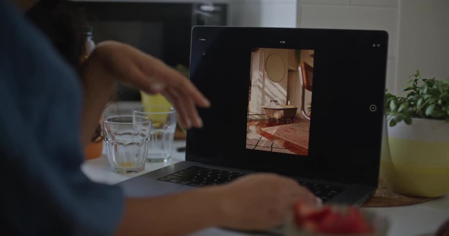 Man and woman in kitchen at breakfast time looking at laptop and discussing home decor