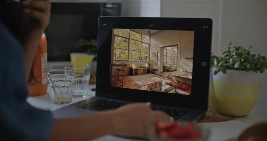 A man and woman look at interior design plans on a laptop computer