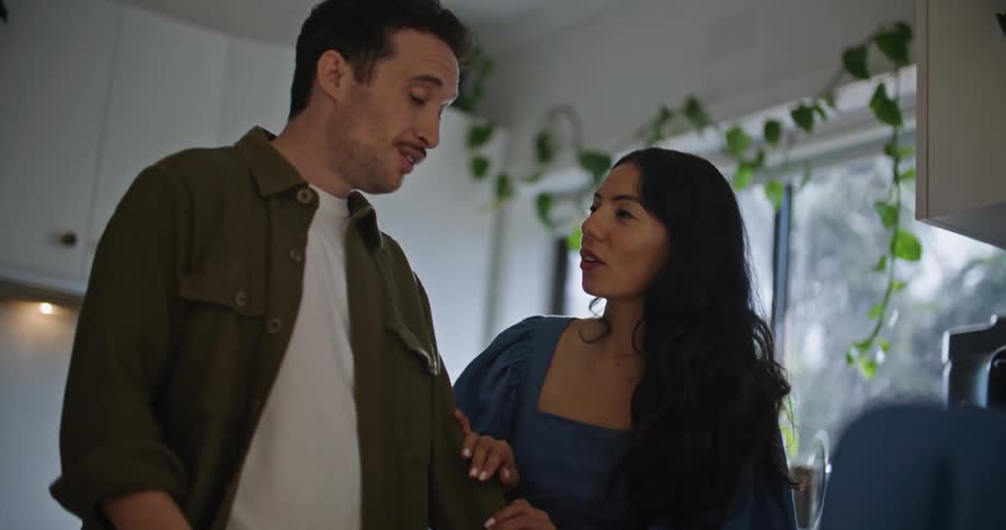 A man and a woman have a conversation in the kitchen of their home