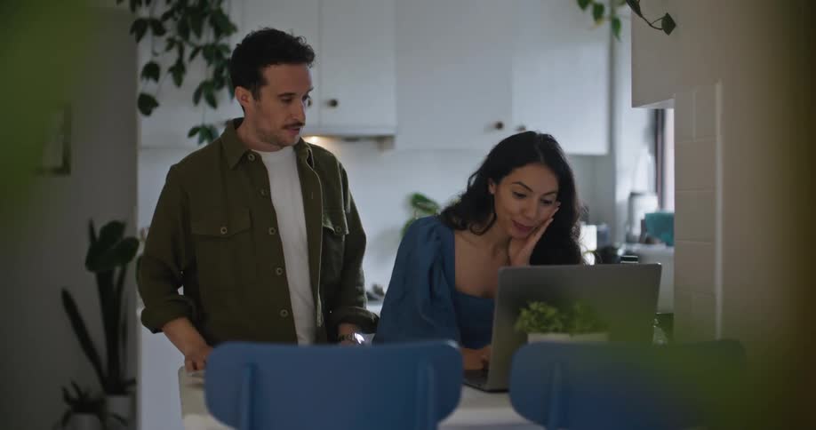 A man and woman talk by the laptop
