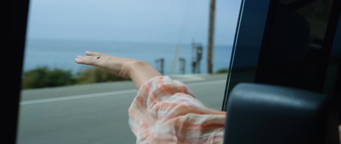 Driving along pacific coast highway with arm hanging out drivers side feeling the ocean breeze