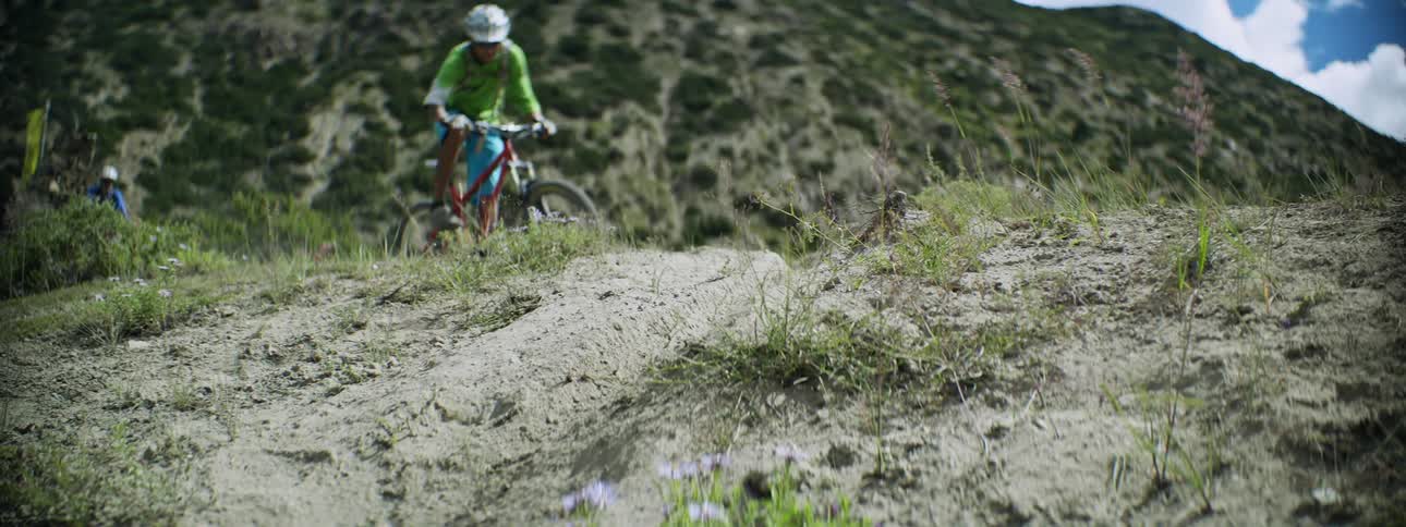 Thrilling Downhill Cycling: Helmeted Cyclist in Green Jersey