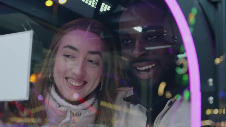 Couple standing close together smiles and talks near glass at amusement park
