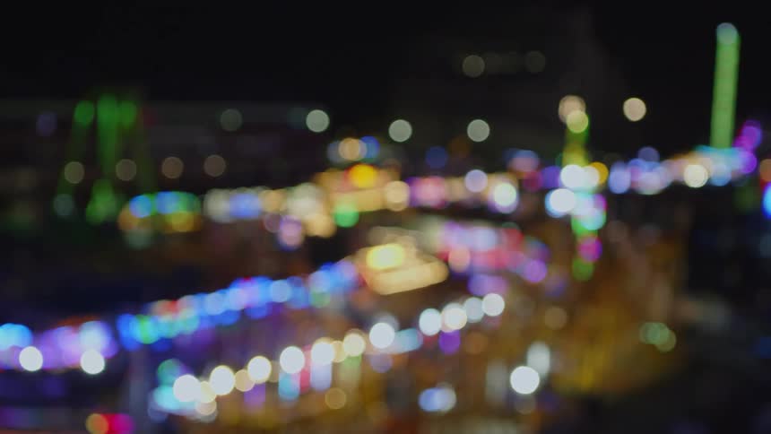 Pov from ferris wheel carnival lights blurred out at nighttime