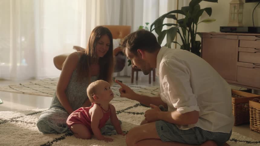 Parents sitting over the rug in the living room playing with their daughter
