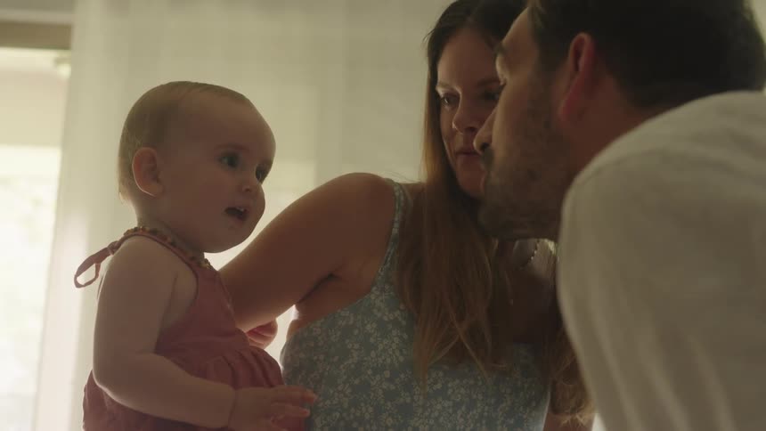 Happy parents playing with their daughter in the living room at home