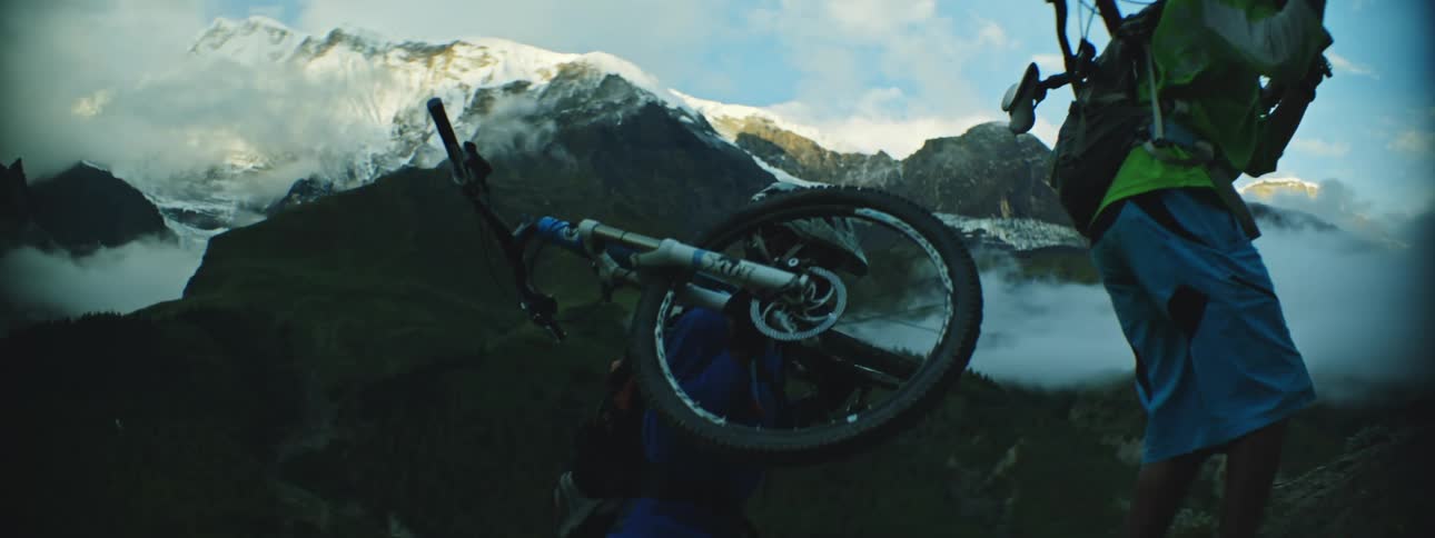 Mountain Bikers Carrying Bikes Uphill in Full Gear