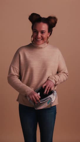 A teenager smiles as she unzips her fanny pack