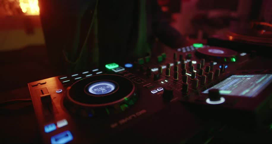 Close up of the hands of a musician turning knobs on a dj console