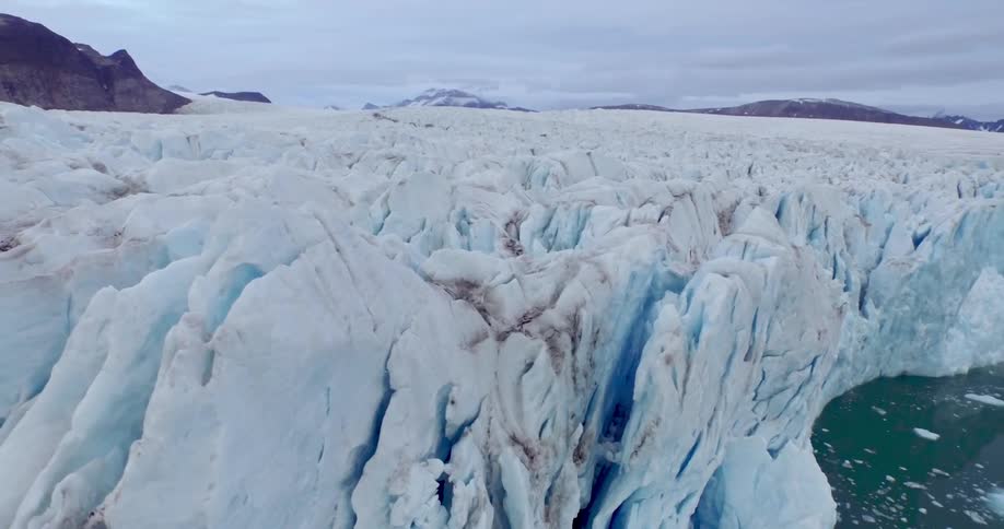 A large ice wall sits near the shore