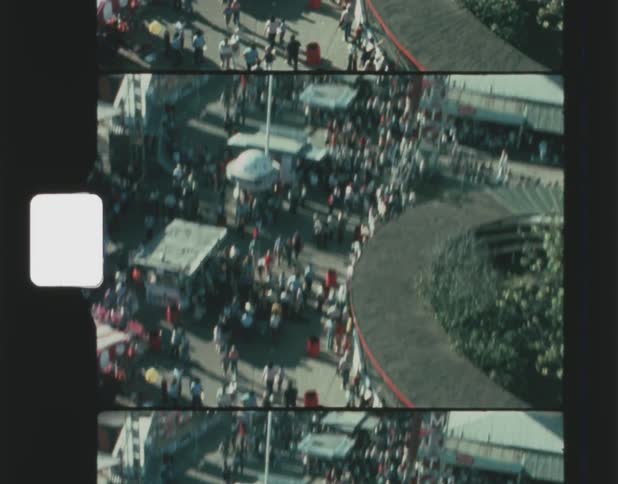 Visitors to amusement park move about booths