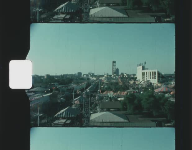 A large crowd of people can be seen from above from an amusement park ride