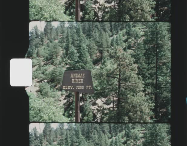A sign marks the spot for a river crossing in the woods