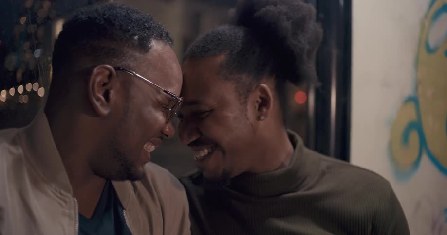 To men smile as then lean in and touch their foreheads together