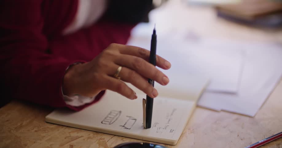 A girl taps her pen on her notebook while studying