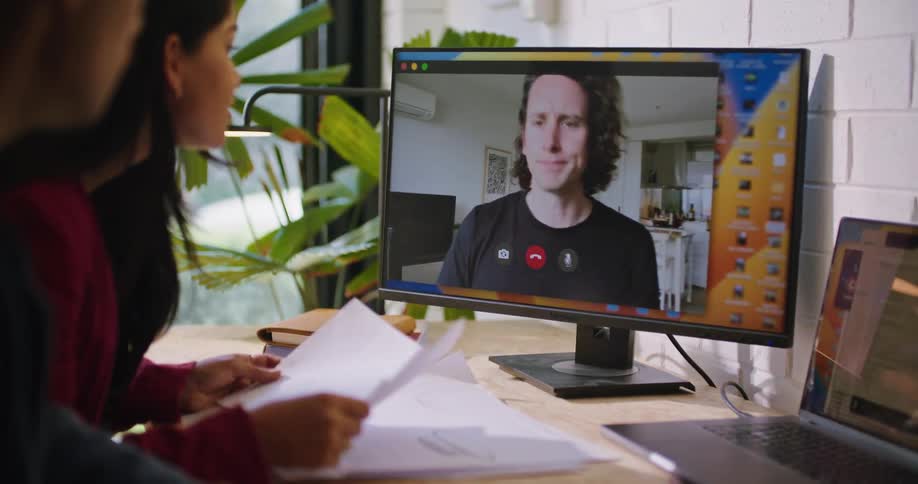 A man talks to two people on a zoom call