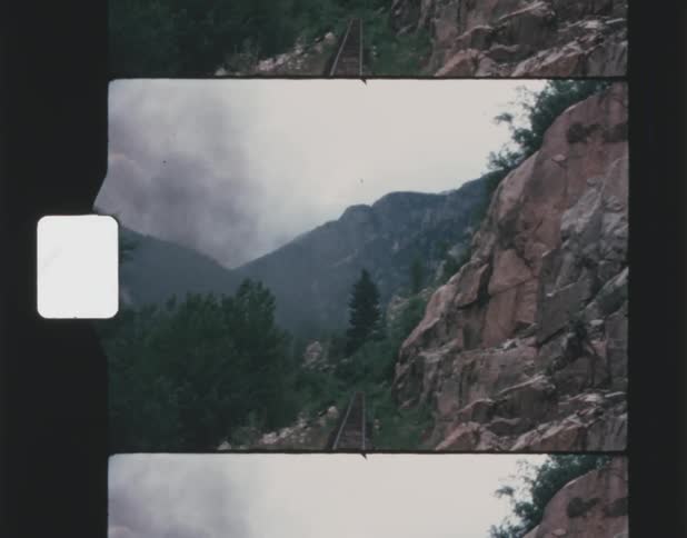 The train track runs on the side of the mountain