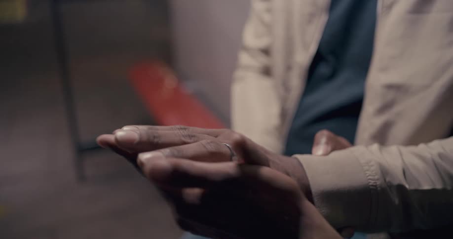 A close up of hands as two men admire a wedding ring
