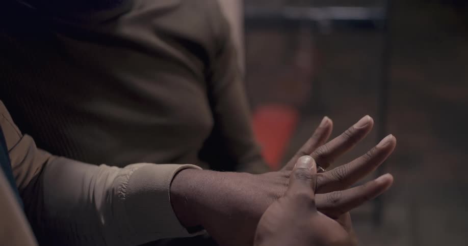 A man looking at his engagement ring with his male partner sitting next to him