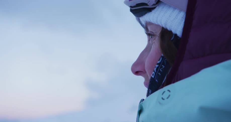 A woman wearing winter gear looks to the left
