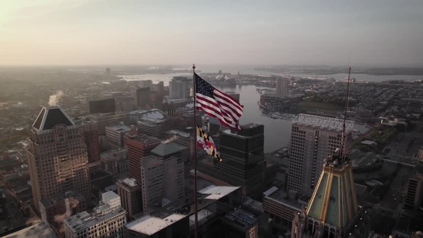 An american flag is flying on top of the building in Batimore