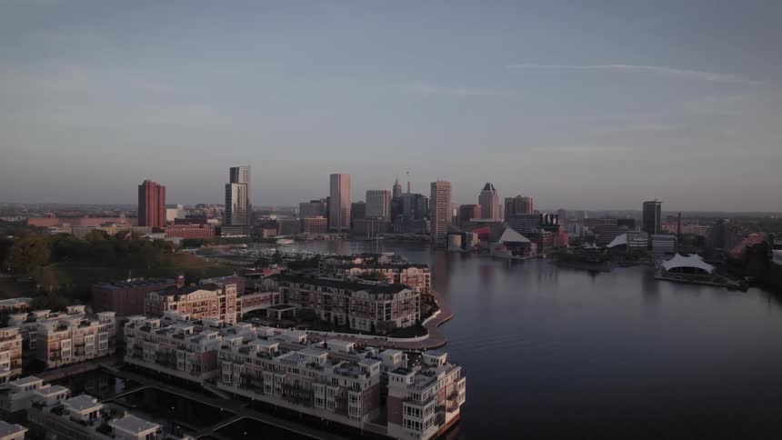 Aerial view of a Batimore downtown city near a harbor body of water is displayed